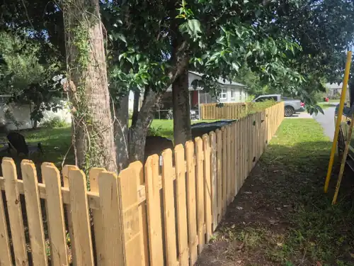 Wood shadow box fence installation in Flagler Beach around a tree